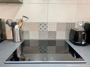 a kitchen counter with a sink and a microwave at L'École Buissonnière in Saint-Vigor-le-Grand