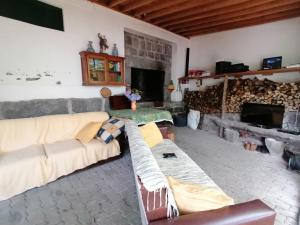 a living room with a couch and a fireplace at Quinta do Areeiro in Horta