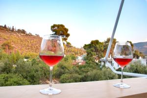 two glasses of red wine sitting on a table at Summer Feel suites in Poros +44 photos