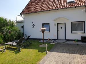 a white house with a table and chairs in the yard at Anbau in Evestorf