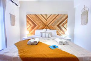 a bedroom with a large bed with a wooden headboard at Summer Feel suites in Poros