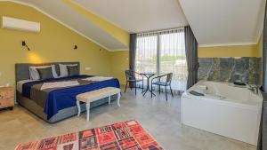 a bedroom with a bed and a table and a tub at Söğüt 3 - 4 Bedroom with jacuzzi in Fethiye in Fethiye +89 photos