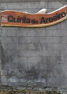 Un cartello su un muro di mattoni con uno skateboard sopra. di Quinta do Areeiro a Horta