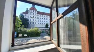 ein offenes Fenster mit Blick auf ein Gebäude in der Unterkunft Neuburg City Apartments in Neuburg an der Donau