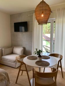salon ze stołem, krzesłami i kanapą w obiekcie Na Wczasowej - Apartamenty w mieście Międzywodzie