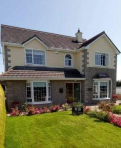 a house with a yard with green grass at Jordan's Drum Haven B&B, Knock in Knock