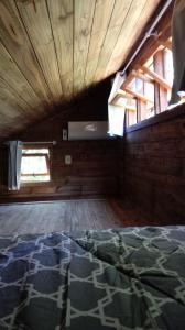 um quarto com um tecto de madeira e um tapete no chão em Tiny House II - Sítio dos Wolff em Gravataí