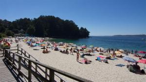 tłum ludzi na plaży blisko wody w obiekcie Precioso apartamento en Marín. w mieście Marín