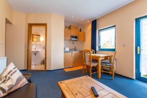 a living room with a table and a kitchen at Hotel Spitzenhoernbucht in Wolgast