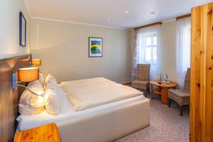 a bedroom with a bed and a table and chairs at Hotel Spitzenhoernbucht in Wolgast