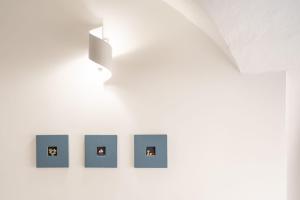 una fila de fotos en una pared en una habitación en La Finestrella, en Parabita