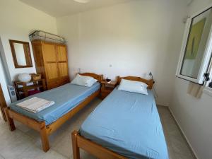 een slaapkamer met 2 bedden en een kast erin bij Appartement in OLIVE GROOVE HOUSE PELOPONNESOS WESTERN MANI in Kalianaíika