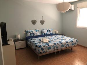 Cette chambre comprend un lit avec des draps bleus et une télévision. dans l'établissement CASA MANUELA, à Chella