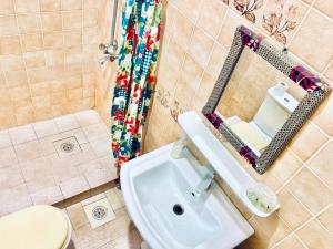 a bathroom with a sink, toilet and bathtub at Bwejuu Beach Palm Villa in Bwejuu