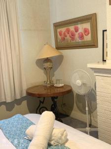 a bedroom with a table with a lamp and a fan at Balwyn 短租房 in Melbourne