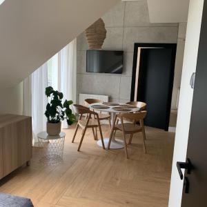 salon ze stołem jadalnym i krzesłami w obiekcie Na Wczasowej - Apartamenty w mieście Międzywodzie