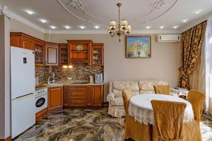 cocina con mesa y nevera blanca en Gefest Apartments, en Odessa