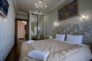 Un dormitorio con una cama grande y una lámpara de araña. en Gefest Apartments, en Odessa