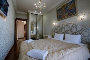 a bedroom with a large bed and a chandelier at Gefest Apartments in Odesa