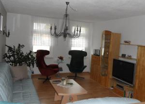 een woonkamer met 2 stoelen en een televisie bij Ferienwohnung an der Therme in Bad Schandau