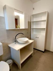 biała łazienka z umywalką i toaletą w obiekcie Dolce far niente apt. w mieście Selca