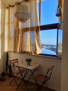 een tafel en stoelen in een kamer met een raam bij Sa Calla Manna in Portoscuso