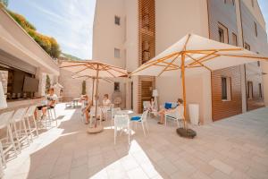 a group of people sitting on a patio with umbrellas at Apartments Villa Jelena in Tivat