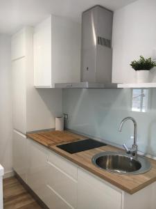 a kitchen with a sink and white cabinets at TeruelHOME I Con Encanto y parking in Teruel