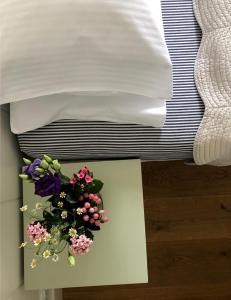 una mesa con flores junto a una cama en Galerie Suites en Mariánské Lázně
