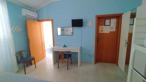 una stanza con una scrivania, un tavolo e delle sedie di Hotel Astor a Silvi Marina Altre 42 foto