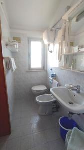 un bagno bianco con un water e un lavandino di Hotel Astor a Silvi Marina