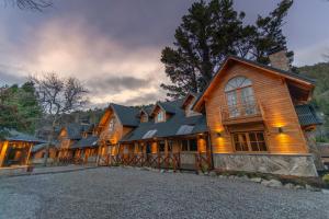 a large wooden house with a lot of windows at Apart Hotel Agua Escondida in San Martín de los Andes