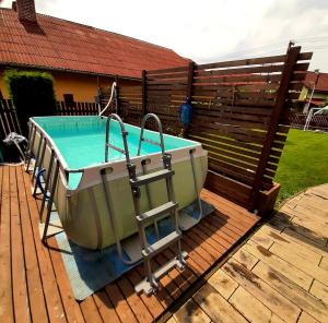 a bath tub sitting on a deck next to a fence at Drevený Raj Apartmán in Hrabušice