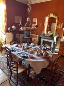 a dining room with a table with food on it at Le Logis in Les Pineaux