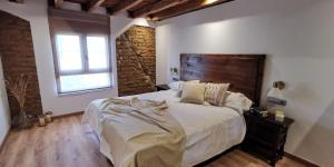 a bedroom with a large bed and a window at Casa Rural Nogalia in Villanueva de los Nabos +23 photos