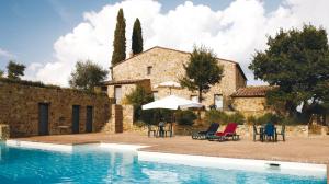 a villa with a swimming pool in front of a house at Agriturismo Podere La Casa in Montalcino
