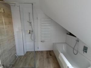a bathroom with a shower and a bath tub at Ferienwohnung Burgblick in Lisberg