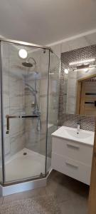 a bathroom with a glass shower and a sink at Villa Fala in Dziwnówek