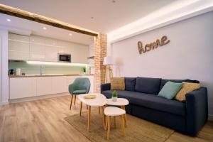 a living room with a blue couch and a table at TeruelHOME III in Teruel