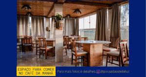 a restaurant with wooden tables and chairs and windows at Pousada Vale de Luz in Frederico Westphalen