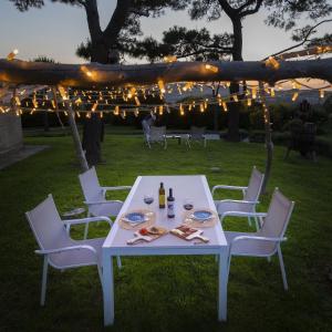 einen weißen Tisch und Stühle in einem Hof mit Lichtern in der Unterkunft Il Mandorlo - Agriturismo e Azienda Agricola Ferrato in Ancona