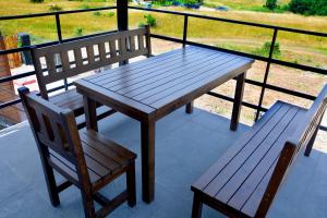 a wooden table and two chairs sitting on a balcony at къщички Поляните in Sinemorets +15 photos