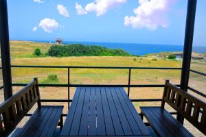 a blue bench sitting on a balcony looking at the ocean at къщички Поляните in Sinemorets