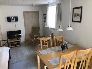 Hyggelig lille lejlighed في إيبلتوفت: غرفة طعام مع طاولة وكراسي وتلفزيون