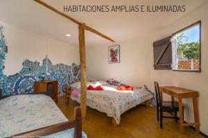 a bedroom with a bed and a table and a chair at Hostal Bambu in San Agustín