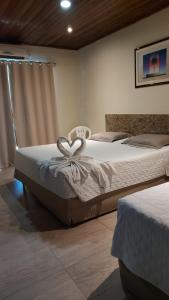 a bedroom with two beds with a heart shapedvisorvisorvisor at Porto Bali Hotel in Santa Cruz Cabrália