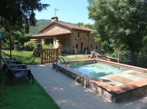 a swimming pool in front of a house at Mas Violella allotjament rural in Sant Joan les Fonts