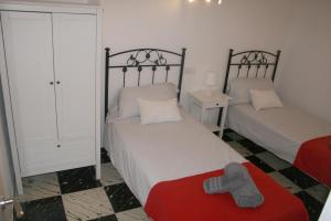 a small bedroom with two beds and a red blanket at Fantastic, 100 meters from the beach in Can Picafort