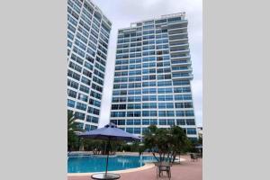 a hotel with an umbrella and two tall buildings at Suite de lujo Punta Centinela in La Libertad