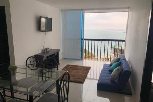 a living room with a blue couch and a glass table at Suite de lujo Punta Centinela in La Libertad